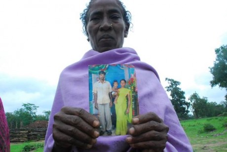 Villager shows photo of murdered loved one.
