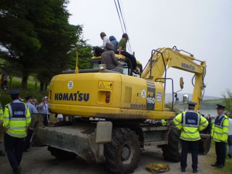Protesters climb on the digger. 