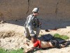This image shows the body of Gul Mudin, the son of a farmer, who was killed on Jan. 15, 2010. A member of the "kill team" is posing behind him