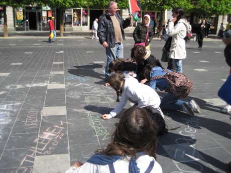Teenagers chalking the names of Palestinian villages on the street